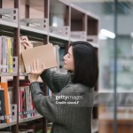 Picking book from bookshelf