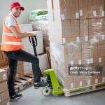 Male warehouse worker transferring boxes full of merchandise